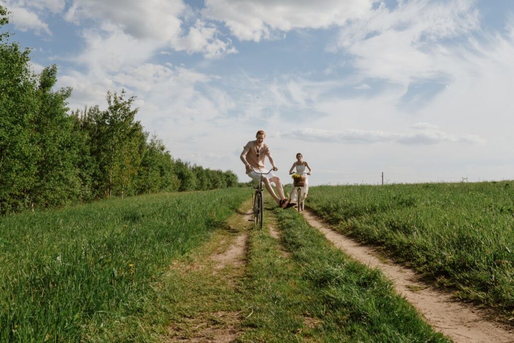 Man en vrouw fietsen over een landweg langs het gras